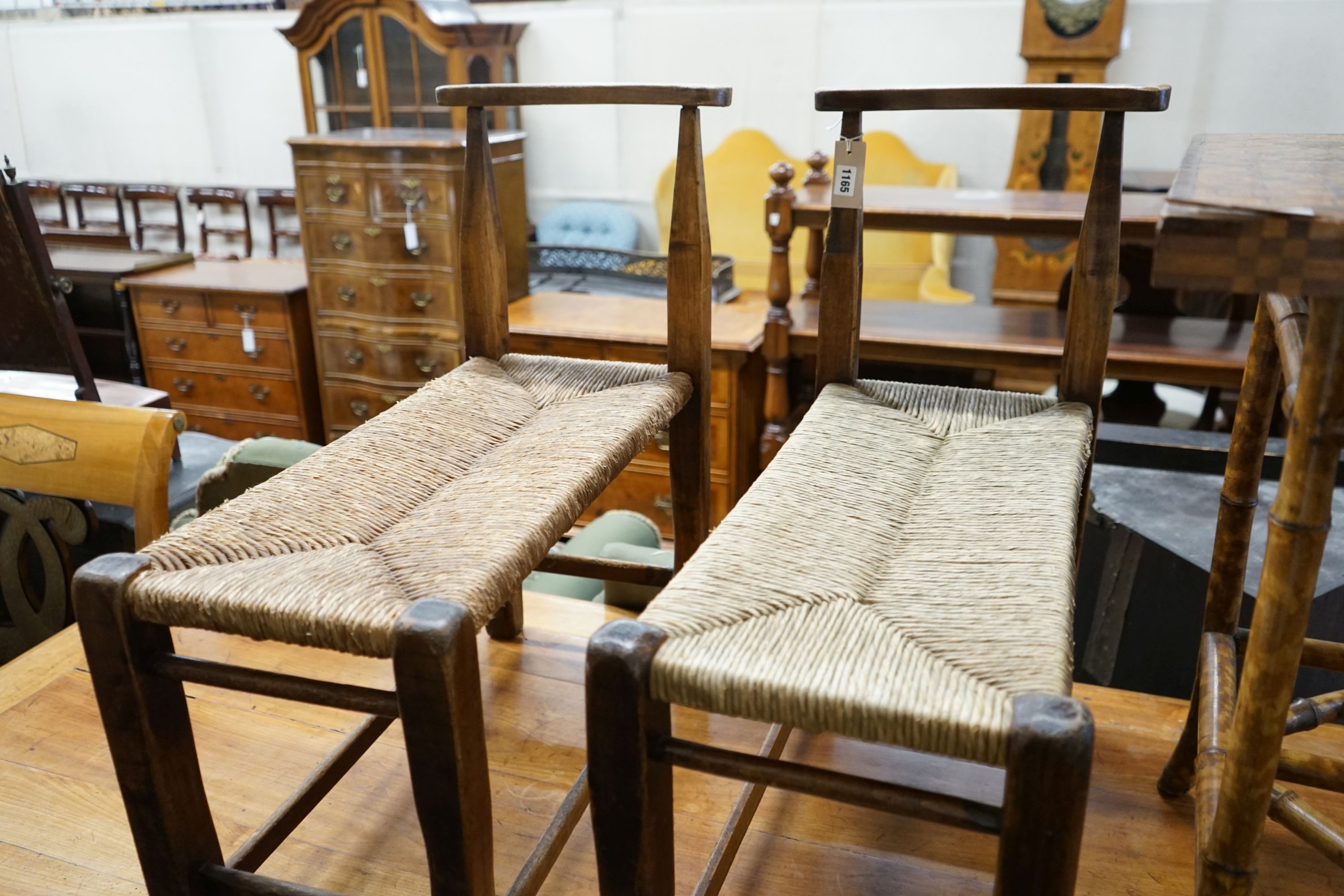 A pair of French provincial oak and beech stools with elongated rush seats, width 31cm, length 67cm, height 73cm